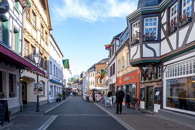 Blick in eine schmale Gasse der Altstadt von Ahrweiler mit historischen Fachwerkhäusern unter blauem Himmel